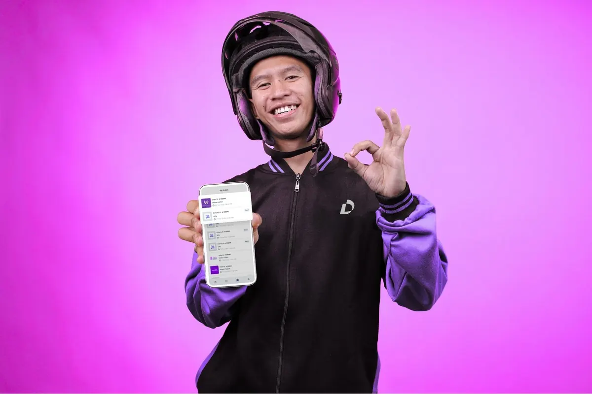 LocalDesi driver smiling holding phone showing completed order history